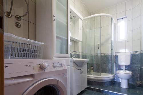 y baño con lavadora y aseo. en Residence Lamba, en Radanovići