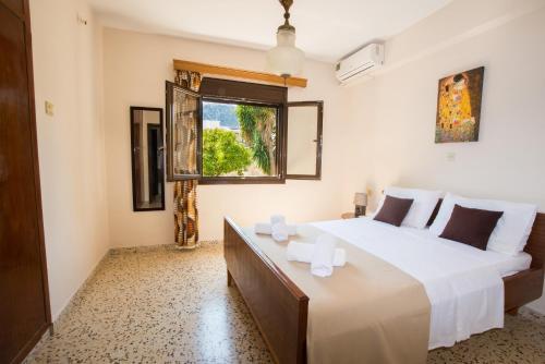 a bedroom with a large white bed and a window at Country House in Pastida