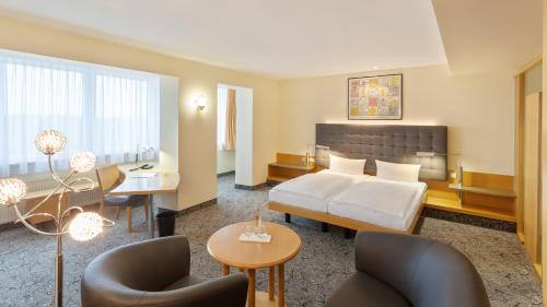 a living room with a couch and a table at ABACUS Tierpark Hotel in Berlin