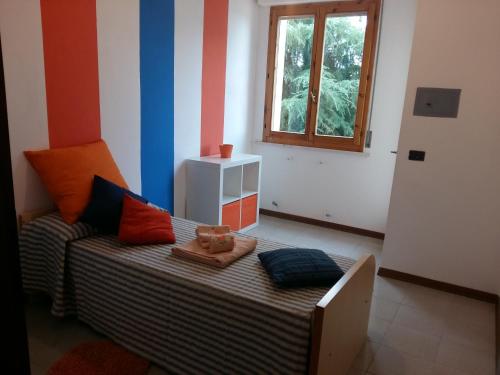 a small room with a bed with colorful stripes at WONDERVIEW GALIMBERTI 18 in Montepulciano