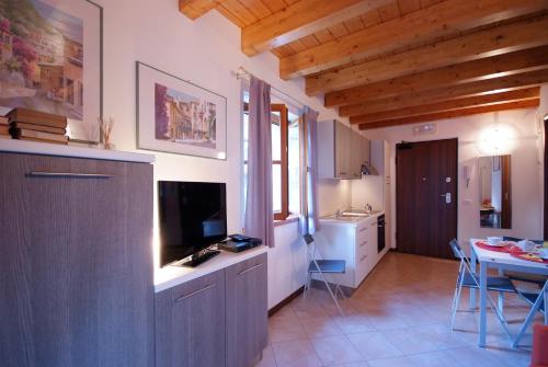 a kitchen and living room with a table and a television at Villaggio delle Alpi in Pré-Saint-Didier