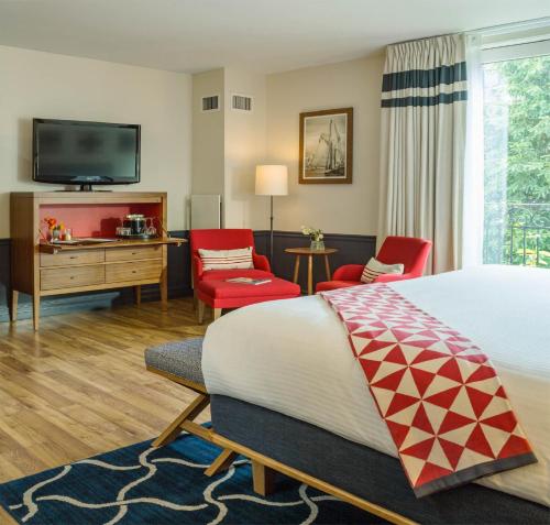 a hotel room with a bed and a flat screen tv at Portland Harbor Hotel in Portland