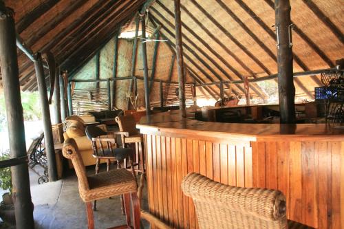 a room with a bar and chairs in a building at Gweta Lodge in Gweta