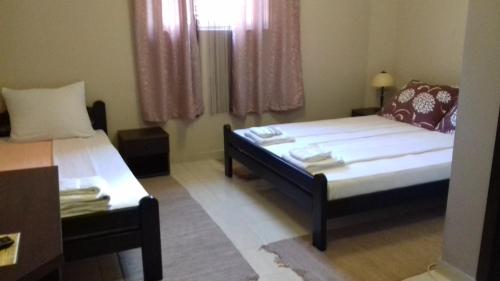 Habitación pequeña con 2 camas y ventana en Asterix Rooms en Leskovac