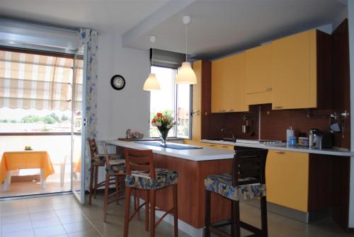 カルダーノ・アル・カンポにあるBnbook Bilo Malpensa 2のキッチン(黄色のキャビネット、バースツール付)