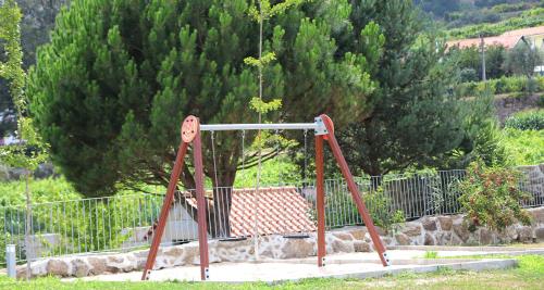 an old swing set in front of a tree at Hotel Rural Quinta das Quintães in Penafiel