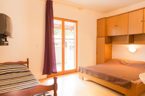Ένα ή περισσότερα κρεβάτια σε δωμάτιο στο Apartmani Antonella