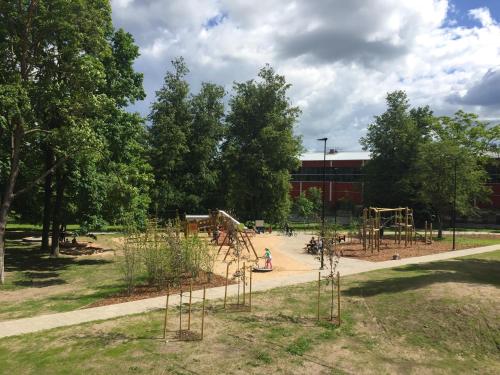 a playground in a park with trees and a building at Tähe Apartment in Tartu