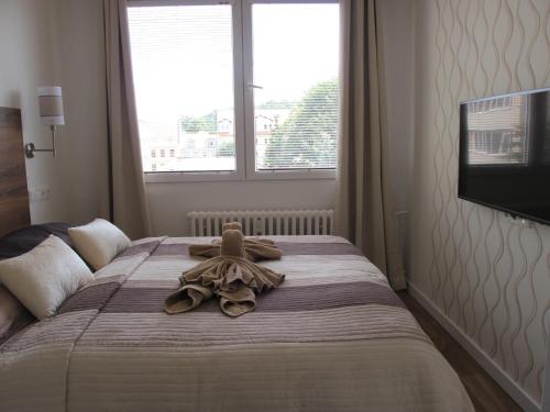 a bedroom with a bed with a teddy bear on it at Jenys Apartment in Teplice