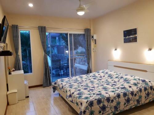 a bedroom with a bed and a view of a balcony at Belinda Home in Ko Si Chang