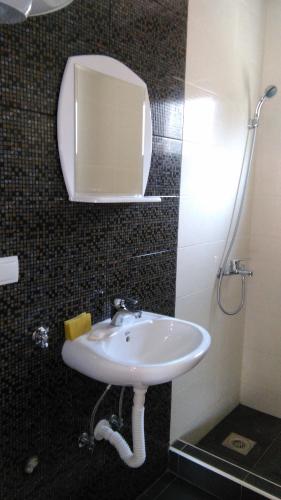 a bathroom with a sink and a mirror at Aparmani Family 1 in Sutomore