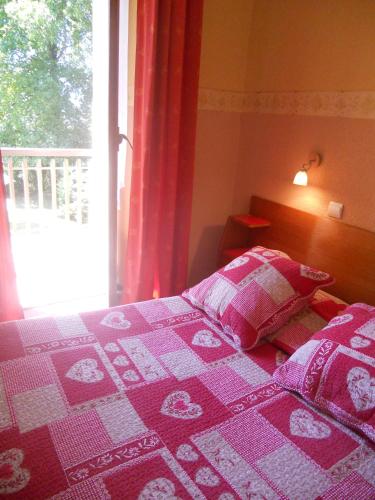 a bedroom with a pink bed with a window at Hotel Bellevue in Ayse
