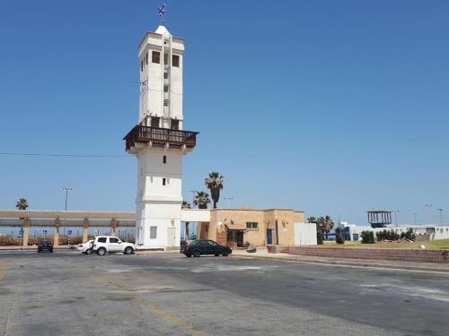 a light house with cars parked in a parking lot at Villa Miami in Ashdod