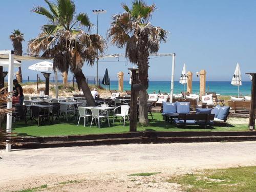 a restaurant with tables and chairs on the beach at Villa Miami in Ashdod