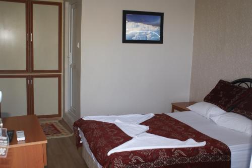 a hotel room with a bed and a picture on the wall at Hotel Dort Mevsim in Pamukkale