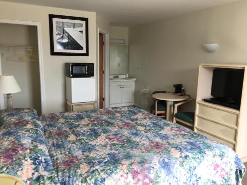 a hotel room with a bed and a television at Point 1 Resort & Motel in Westerly