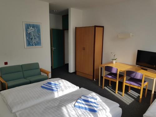 a hotel room with a bed and a table and a desk at Appartement-Hotel Rostock in Rostock