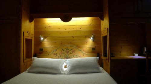 a bed with a pillow on top of it at Hotel Du Parc - Manoir Du Baron Blanc in Faverges