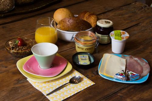 a table with a breakfast of bread and orange juice at B&B De Vrome Vos in Mechelen