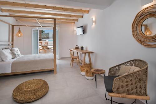a bedroom with a bed and a table and chairs at Casa Vitae Suites in Kamari