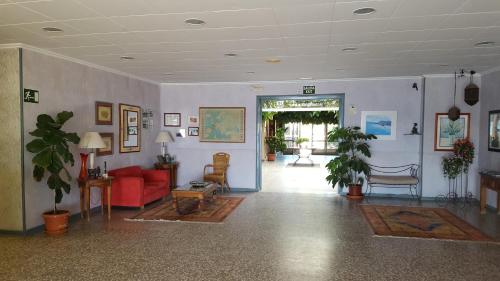 a living room with a red couch and chairs at Bahía - 30º hotels in Puerto de Mazarrón