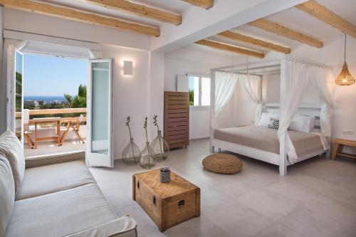 a bedroom with a bed and a couch and a table at Casa Vitae Suites in Kamari