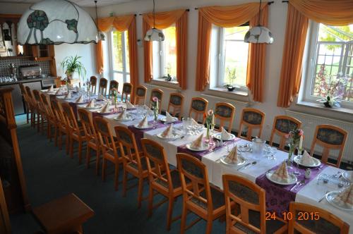 a long dining room with a long table and chairs at Turmhotel Schwedt in Schwedt