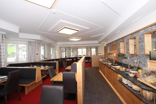 a dining room with tables and chairs in a restaurant at Hotel Bärolina in Serfaus
