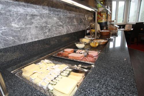 a buffet line with different types of cheese and meats at Hotel Bärolina in Serfaus