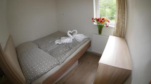 łóżko z białym łukiem w pokoju w obiekcie Všemina Apartman w mieście Lužkovice