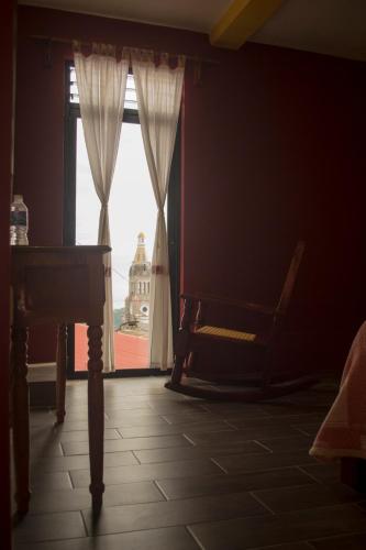 a room with a window with a chair and a table at Posada El Volador in Cuetzalán del Progreso