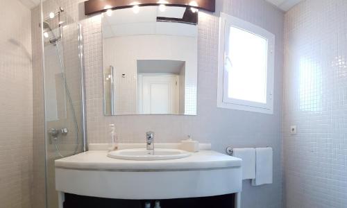 a white bathroom with a sink and a mirror at Alameda San Lorenzo Loft in Seville