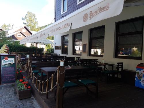 a restaurant with tables and chairs on a patio at Penzion Varšavjanka in Harrachov