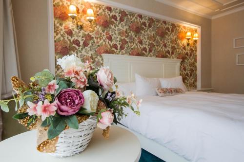 a bedroom with a bed and a basket of flowers on a table at Hotel Dragului in Predeal