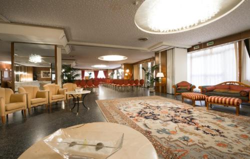 a lobby with a waiting area with chairs and a rug at Hotel Royal Palace in Messina