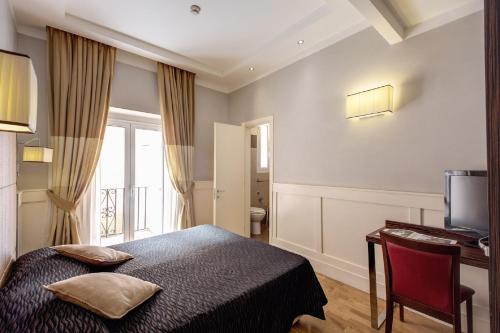 a bedroom with a bed and a desk and a television at 939 Hotel in Rome