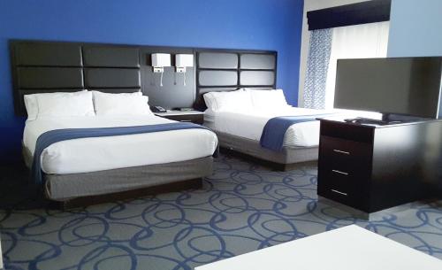 a hotel room with two beds and a flat screen tv at Holiday Inn Express Hotel & Suites Lawrenceville by IHG in Lawrenceville
