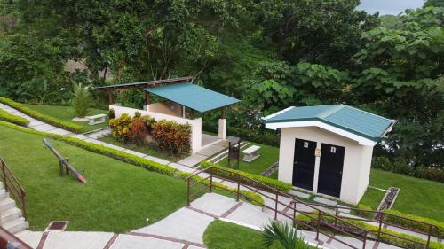 a small building with a blue roof in a park at Villa privada con Jacuzzi Herradura Jaco in Herradura