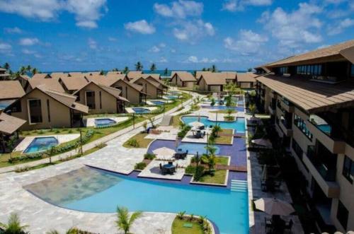 uma vista aérea de um resort com várias piscinas em Flat de 2 quartos, Nui Supreme Beach, Praia do Muro Alto Porto de Galinhas em Porto de Galinhas