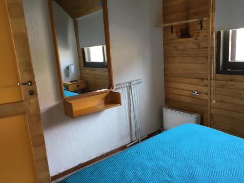 a bedroom with a blue bed and a mirror at Dormy Houses Payen in Las Lenas