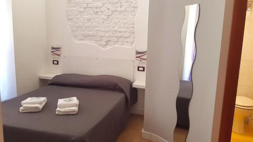 1 dormitorio con 1 cama con 2 toallas en Piumith Guest House, en Roma