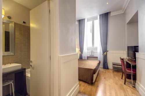 a small bathroom with a bed and a sink at 939 Hotel in Rome