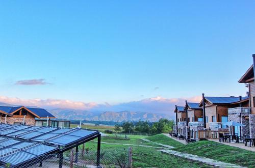 a group of houses with a view of mountains at Blackstone Country Villages Hotel in Villa General Belgrano