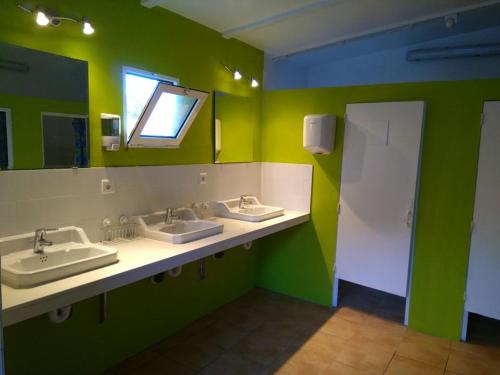Baño público con 2 lavabos y espejo en Camping Santa Clara, en Altea