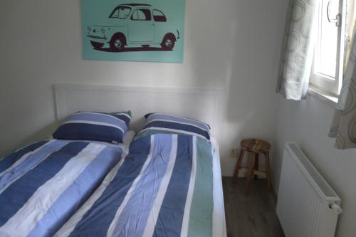 エルメロにあるDolfijnのベッドルーム1室(ベッド2台付)が備わります。壁に車の写真が飾られています。