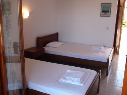 two beds in a room with a mirror at Venia Apartments in Afitos