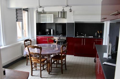 ルーアンにあるLES OISEAUX (L'HIRONDELLE)のキッチン(赤いキャビネット、テーブル、椅子付)