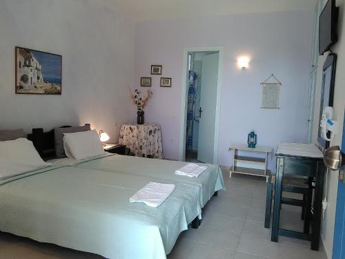 a bedroom with a large bed and a table at Daira Apartments in Diakofti