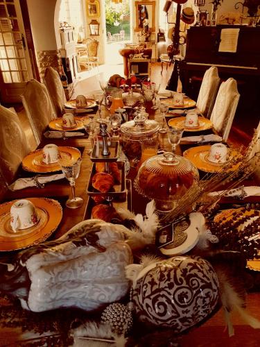 un lungo tavolo con piatti e piatti sopra di La Villa des Remparts a Labastide-dʼArmagnac