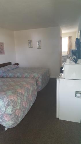 a hotel room with two beds and a desk at Crystal Sands Motel in Wildwood
